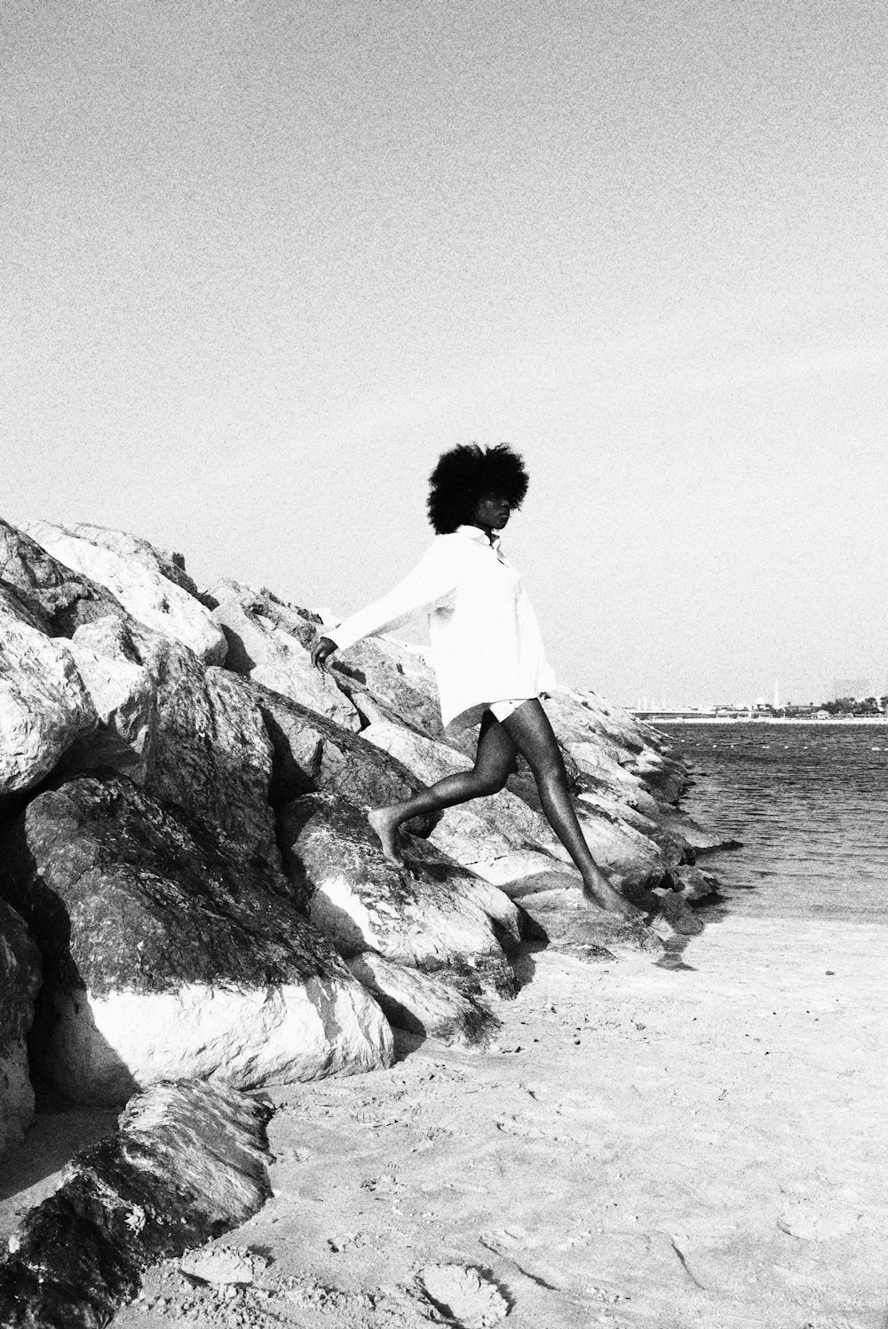 a woman jumping off a rock into the water