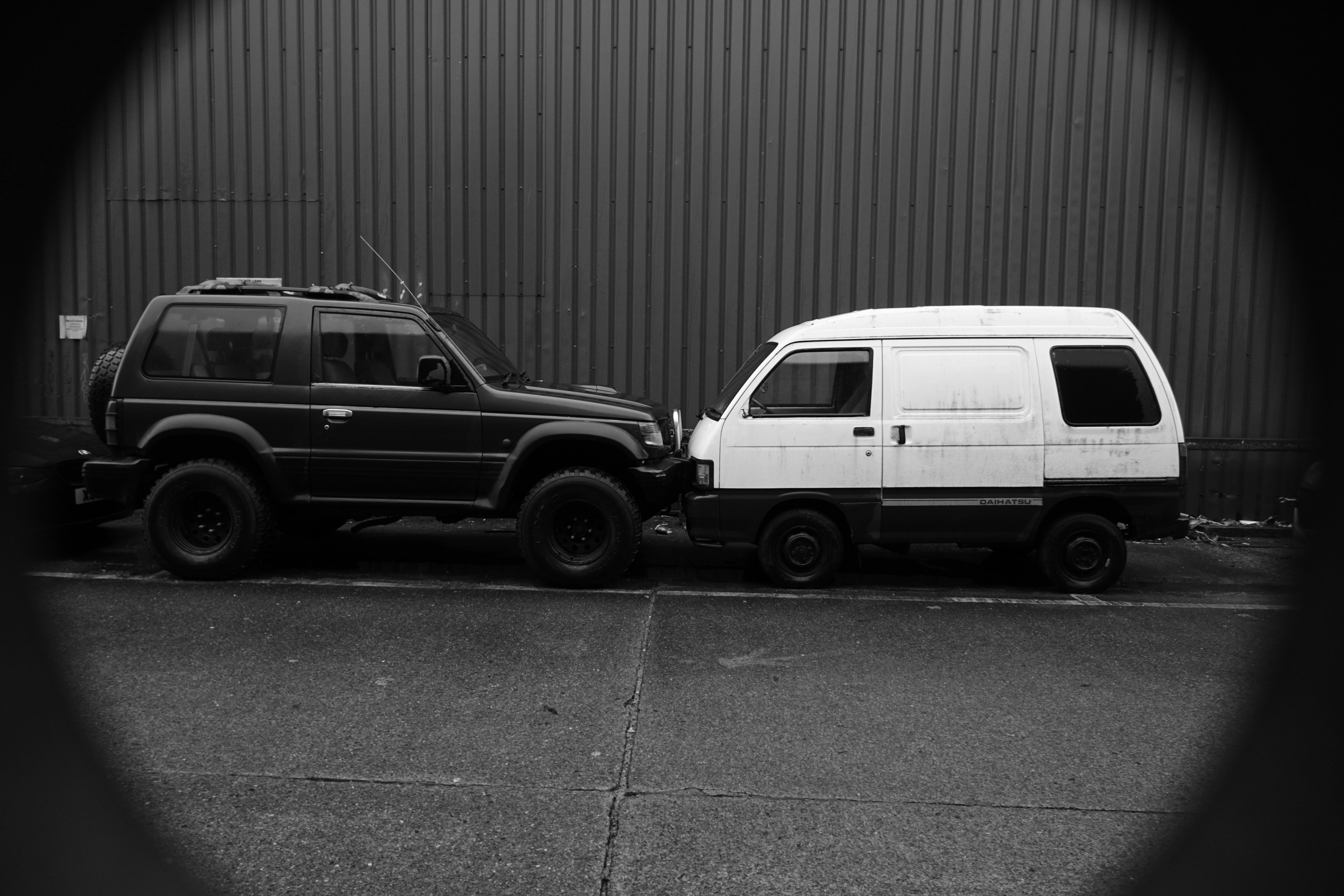 a black and white photo of two cars parked next to each other