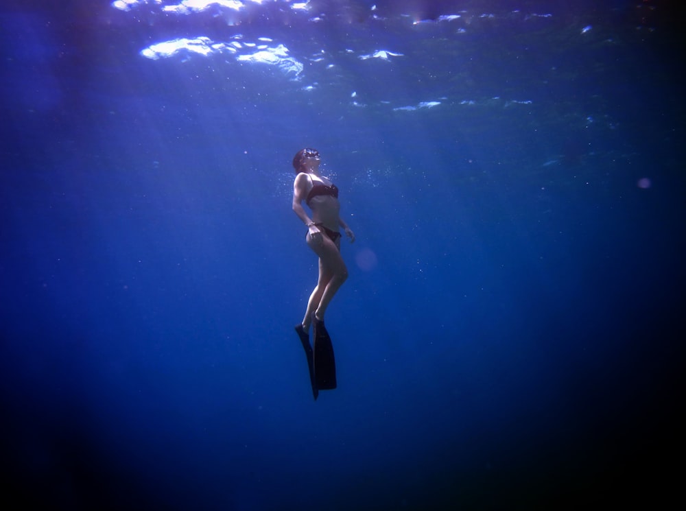 a woman in a bikini swims in the water