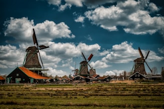 a group of windmills sitting on top of a lush green field