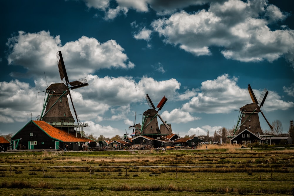 a group of windmills sitting on top of a lush green field