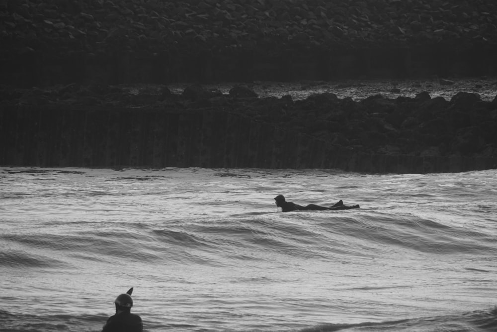 a person laying on a surfboard in the water