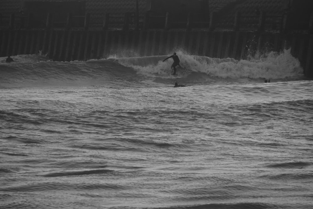 a man riding a wave on top of a surfboard