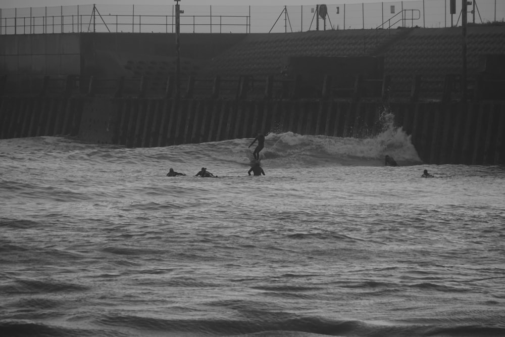 a group of people riding surfboards on top of a wave