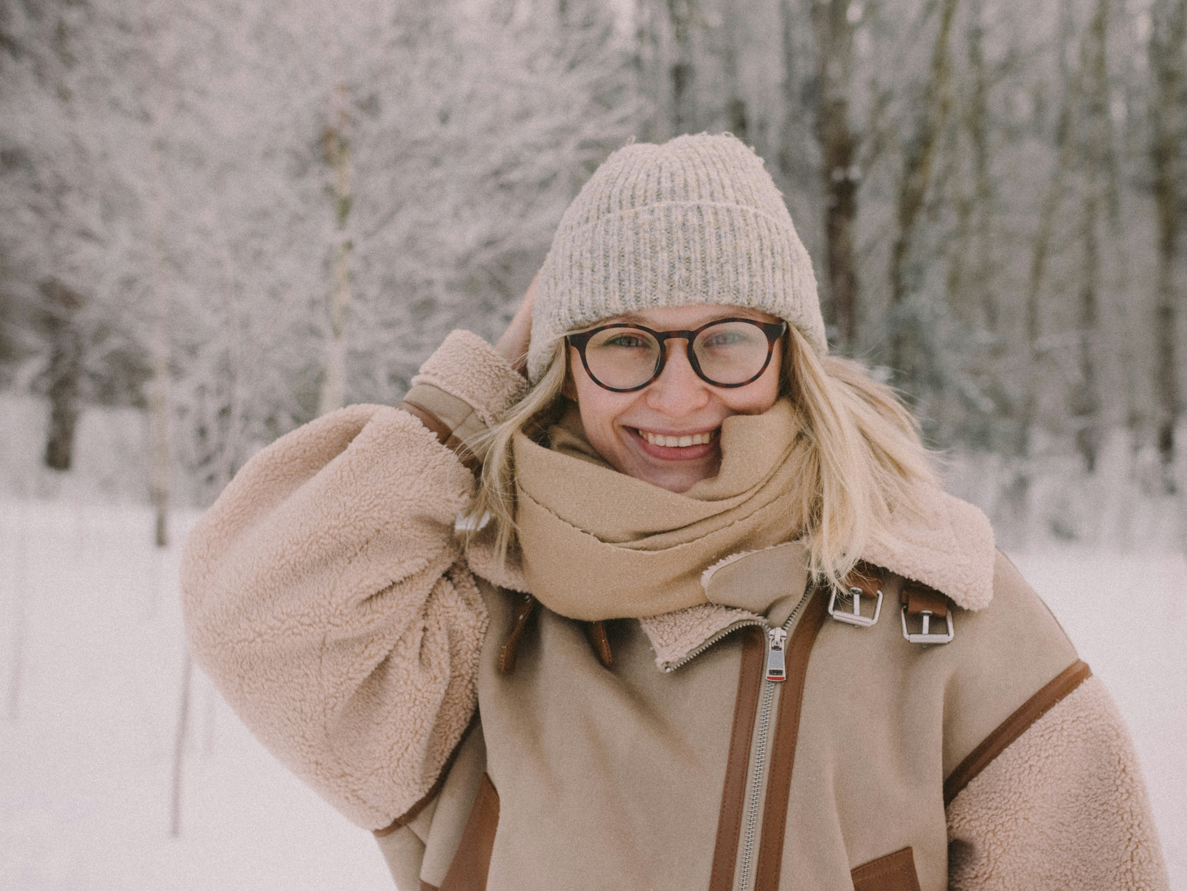 a woman wearing glasses and a scarf in the snow