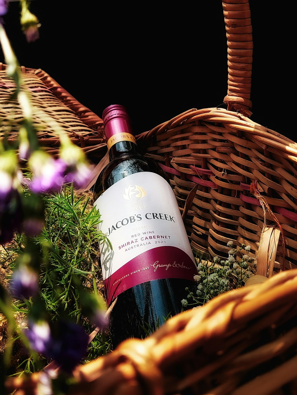 a bottle of wine sitting in a basket