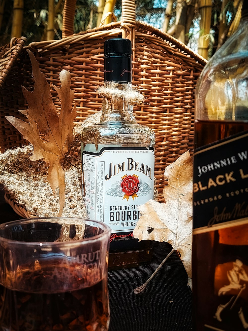 a bottle of john beam bourbon next to a glass
