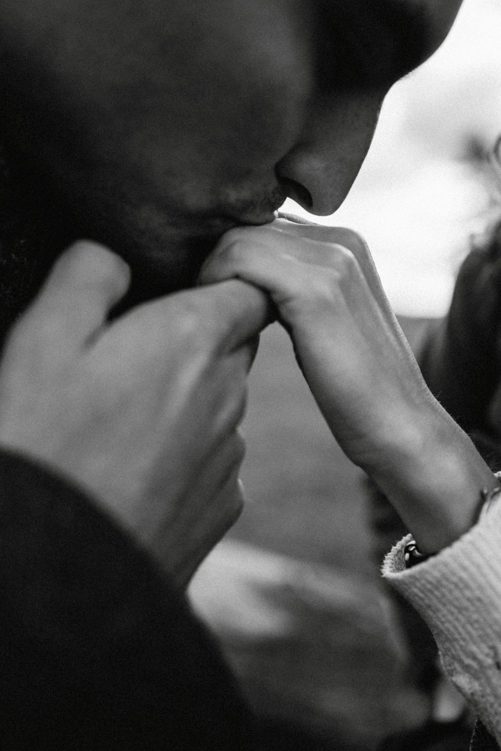 a black and white photo of a man holding a woman's hand