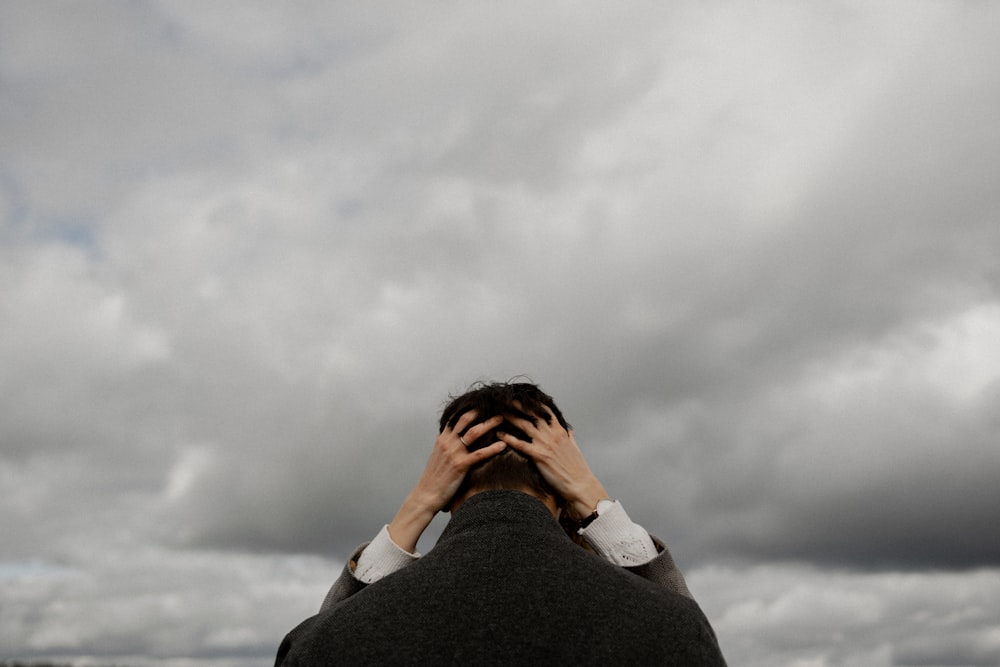 a man covering his face with his hands