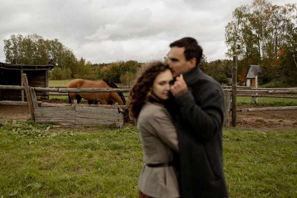 a man and a woman standing in front of horses