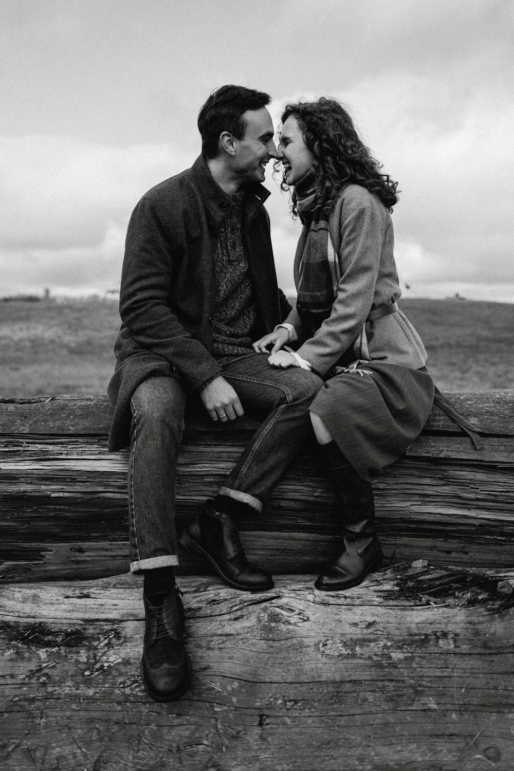 a man and a woman sitting on a log