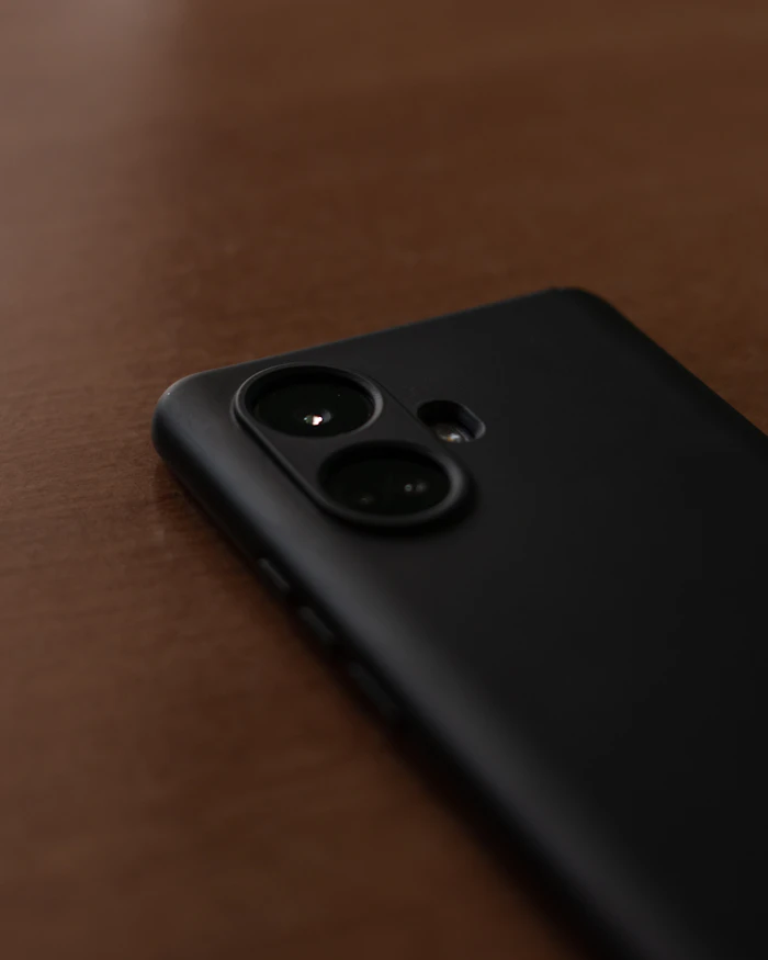 Black smartphone with a triple camera on a wooden table