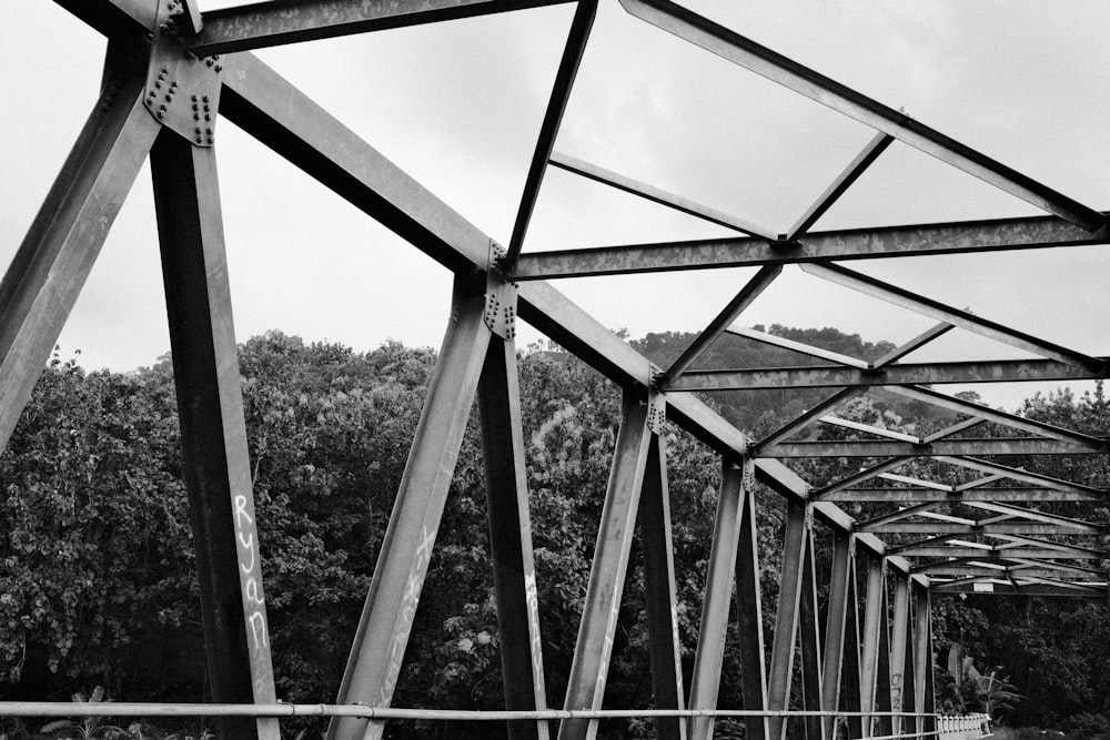 a black and white photo of a metal bridge