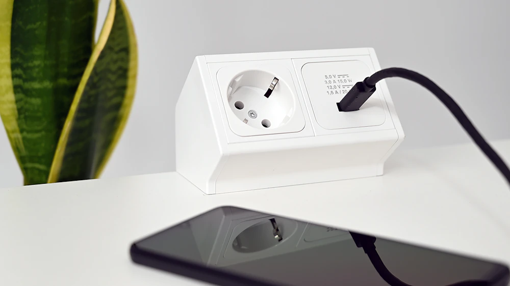 Phone charging beside a desktop power accessory