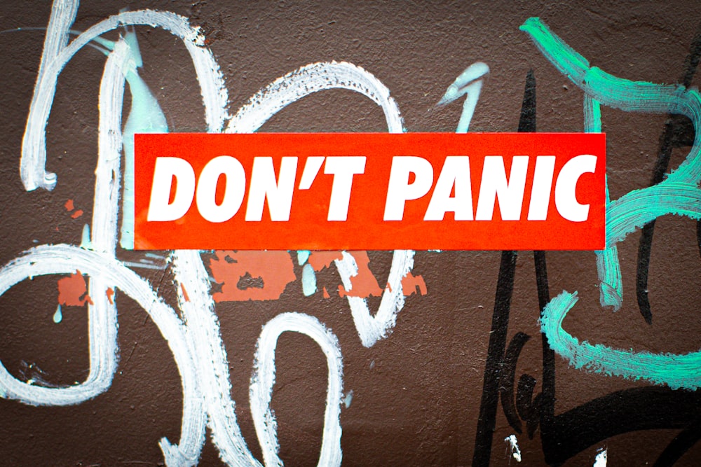 a red don't panic sticker on a wall