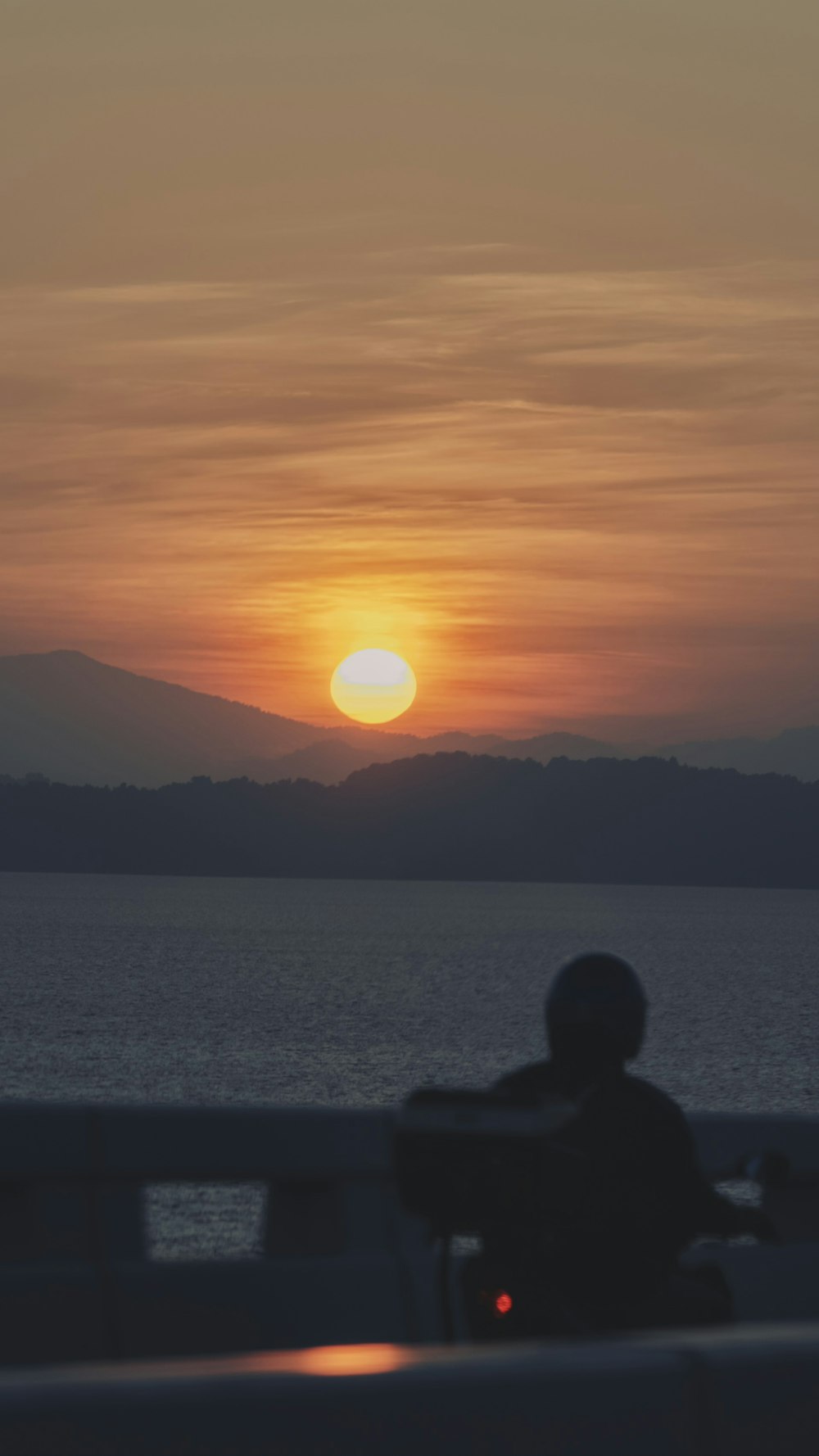 a person sitting on a boat watching the sun set