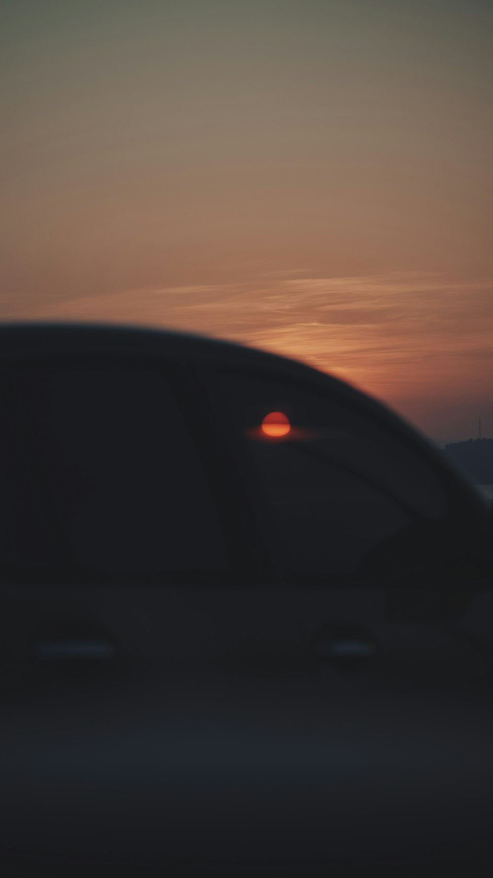 a car with the sun setting in the background