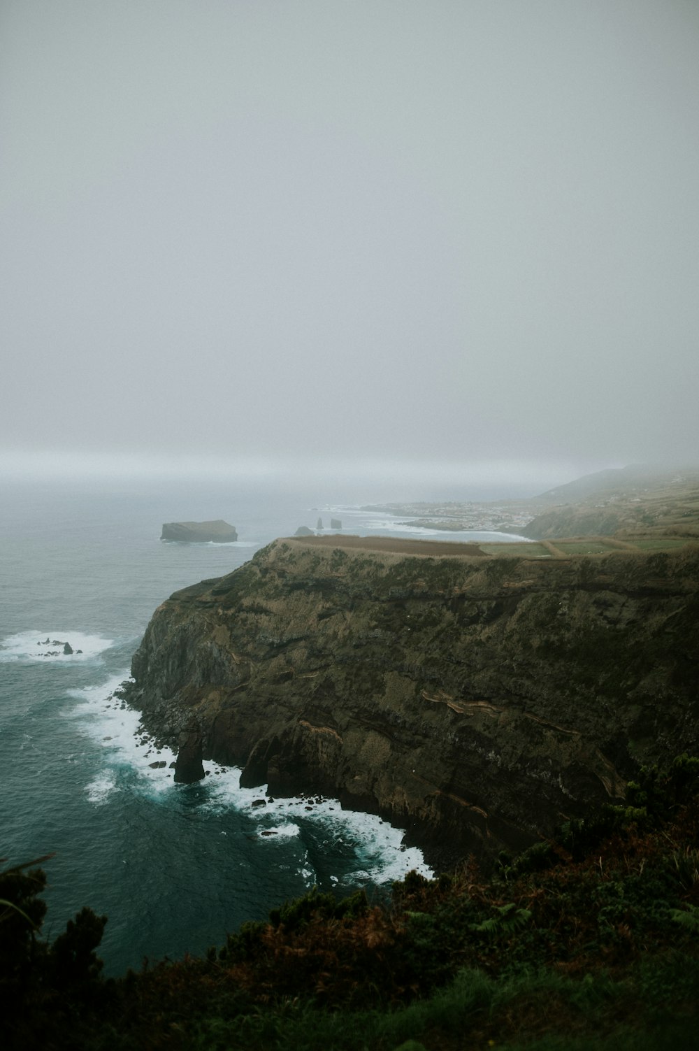 a foggy day on the coast of a large body of water