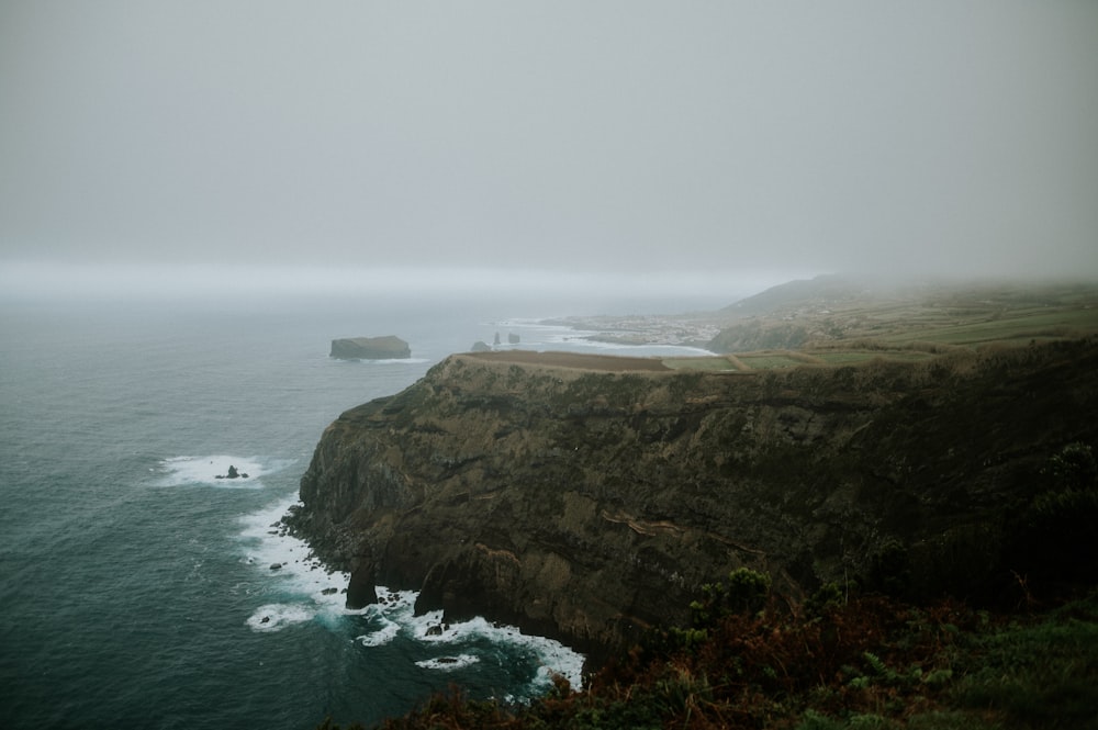 a large body of water sitting next to a cliff