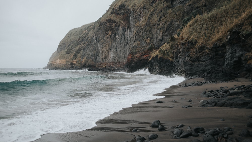 una playa rocosa con olas que llegan a la orilla