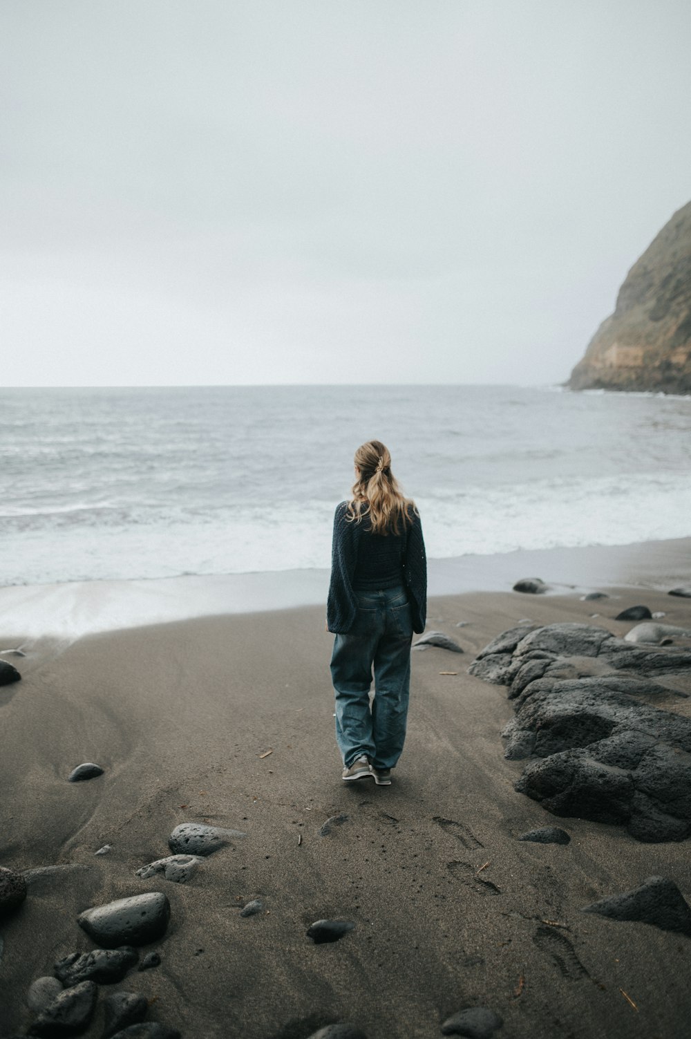 a person walking on a beach near the ocean