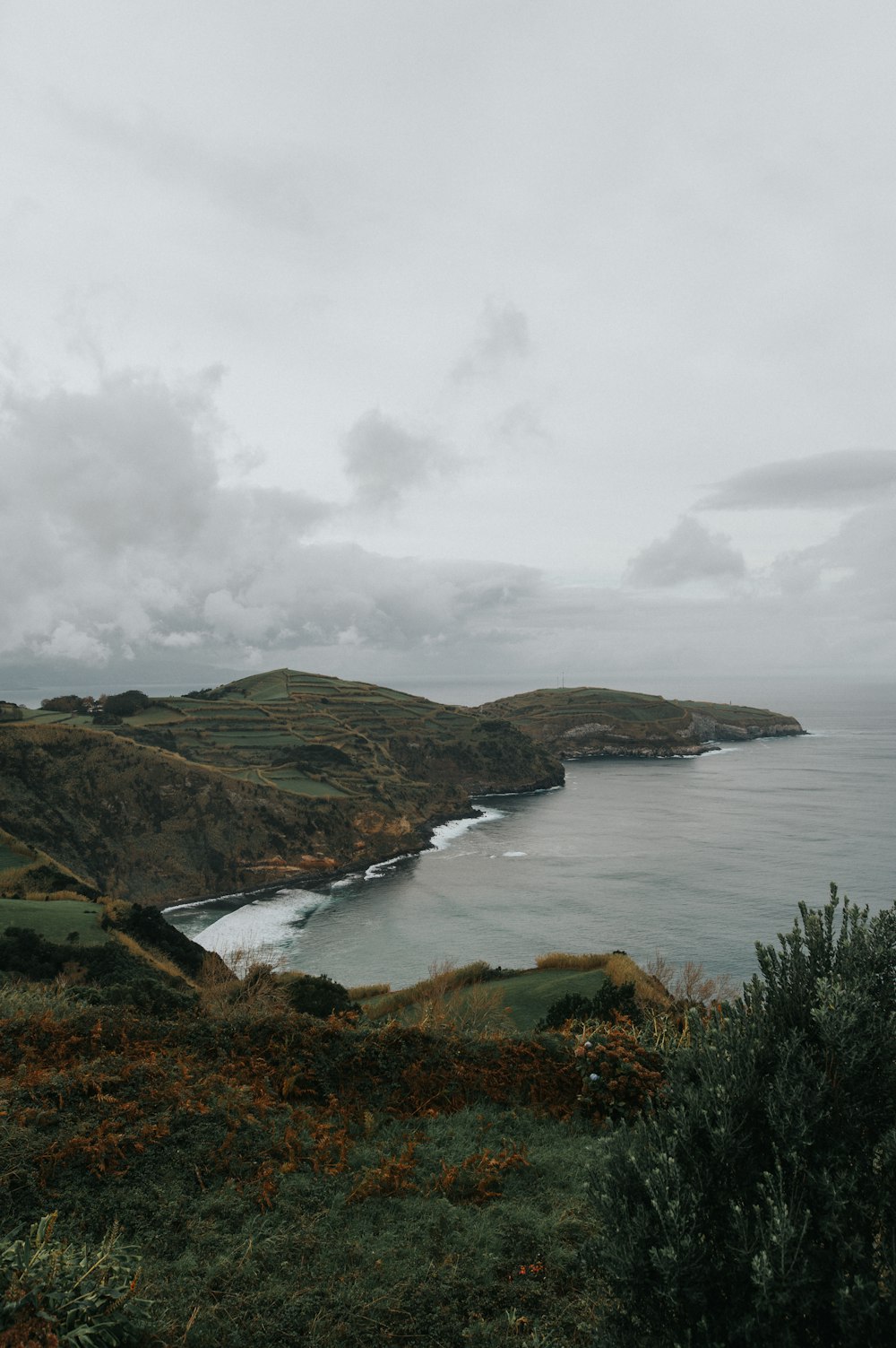 a large body of water surrounded by lush green hills