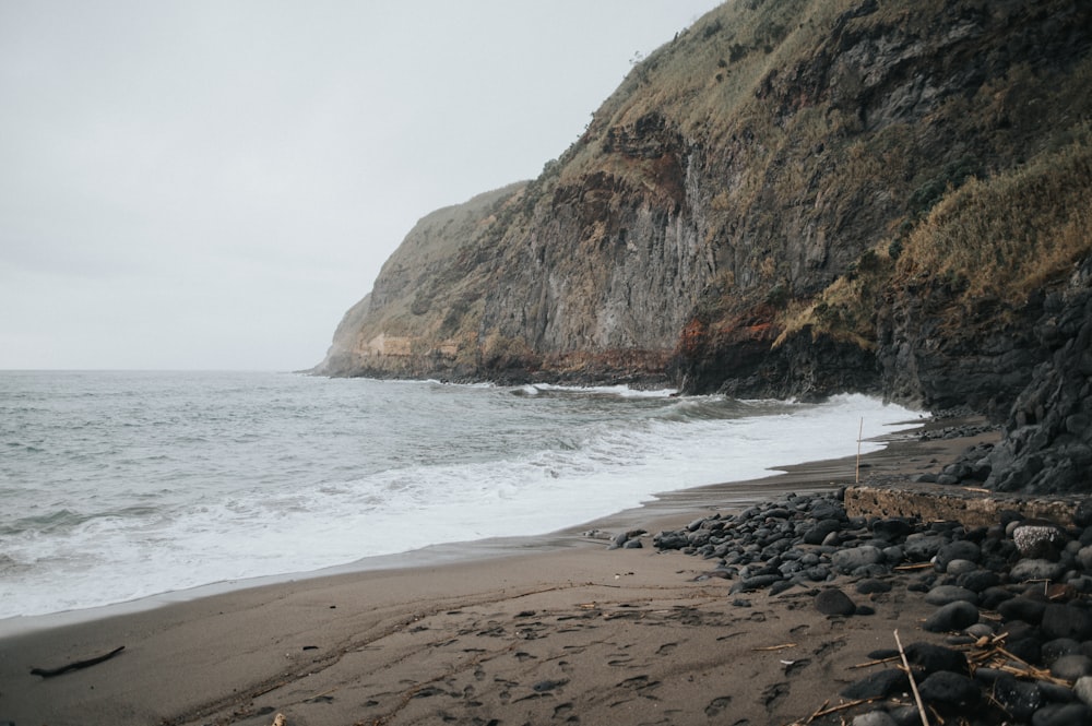 Una playa rocosa junto al océano con un acantilado al fondo
