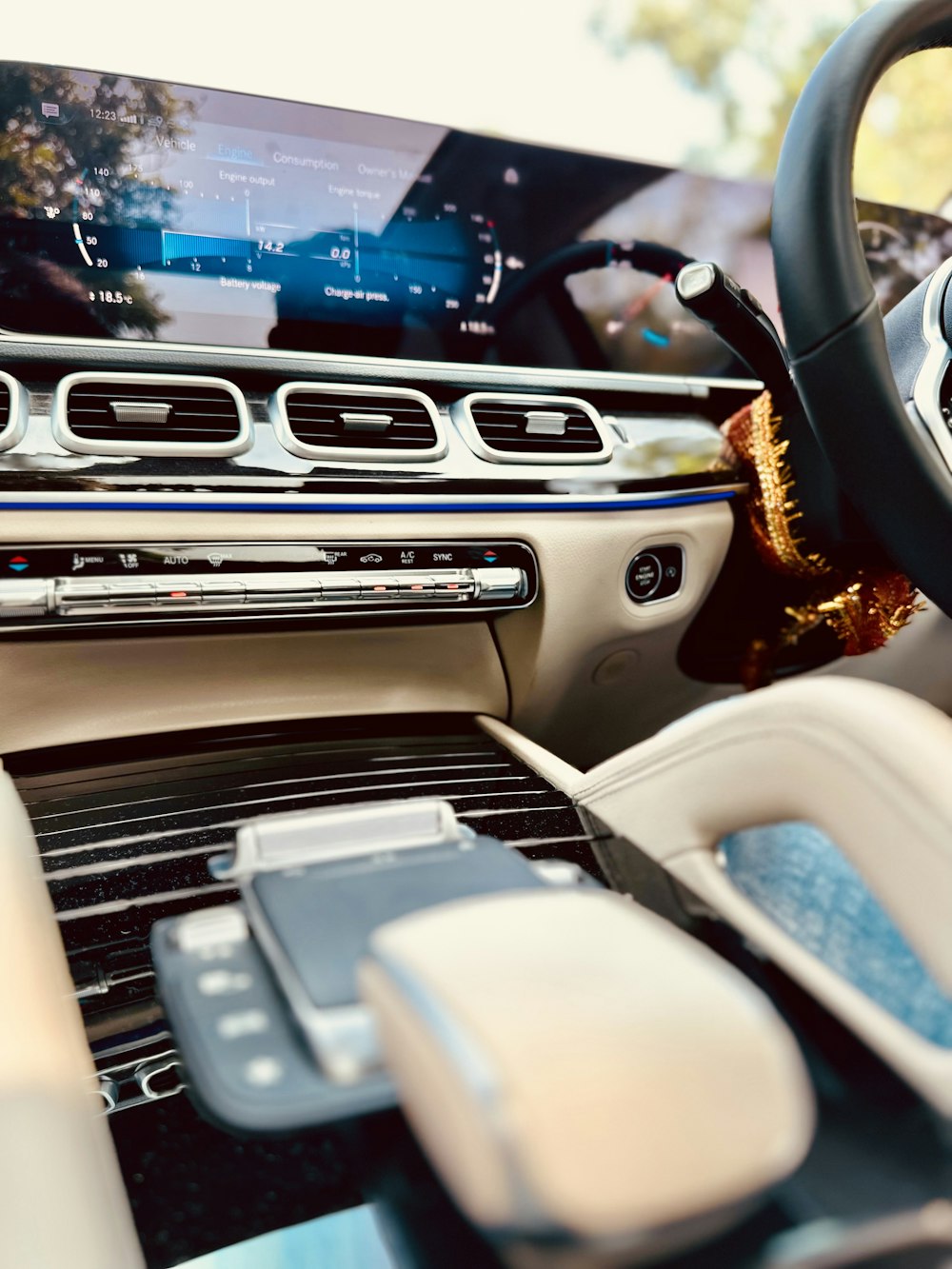 a car dashboard with a cell phone and a steering wheel