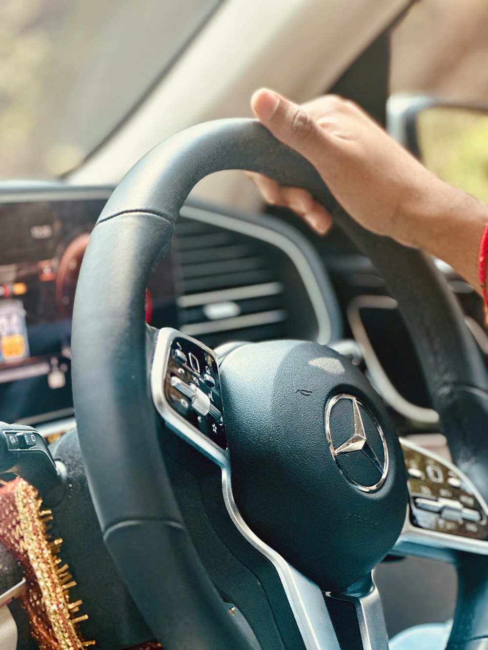 a person holding a steering wheel while driving a car