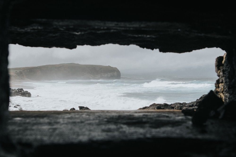 a view of a body of water from inside a cave