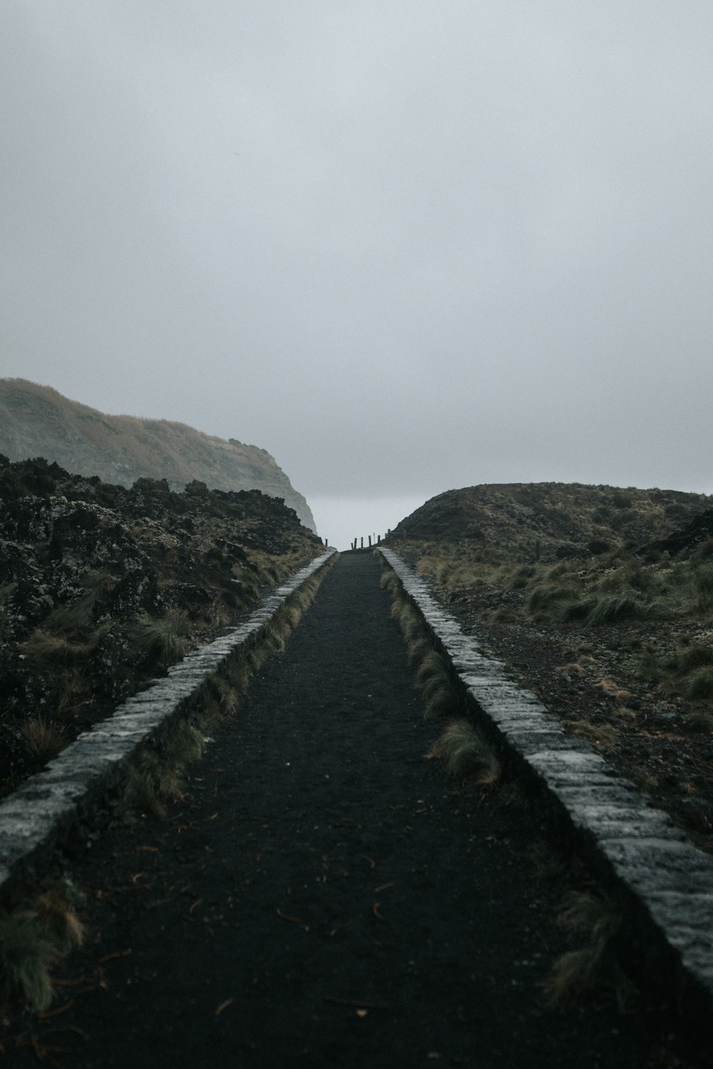 a long straight road with a hill in the background