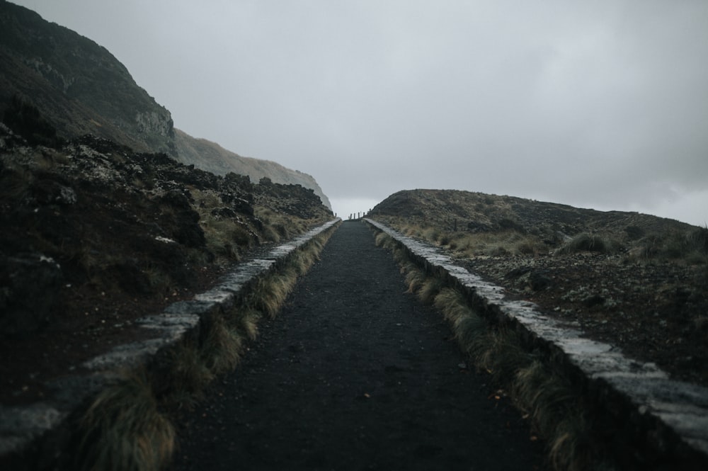 a long narrow road with a mountain in the background