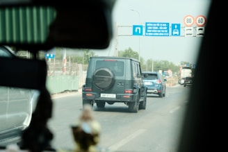 a black jeep driving down a street next to traffic signs