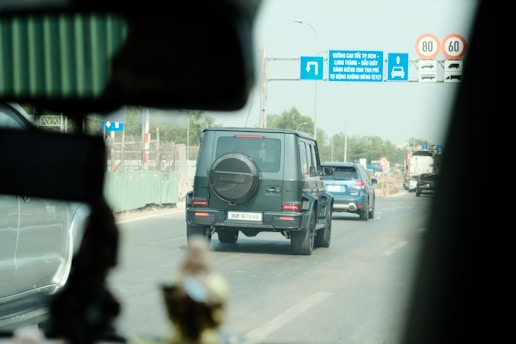a black jeep driving down a street next to traffic signs