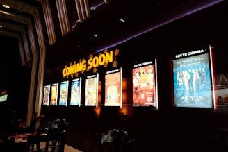 a row of movie posters on the wall of a movie theater