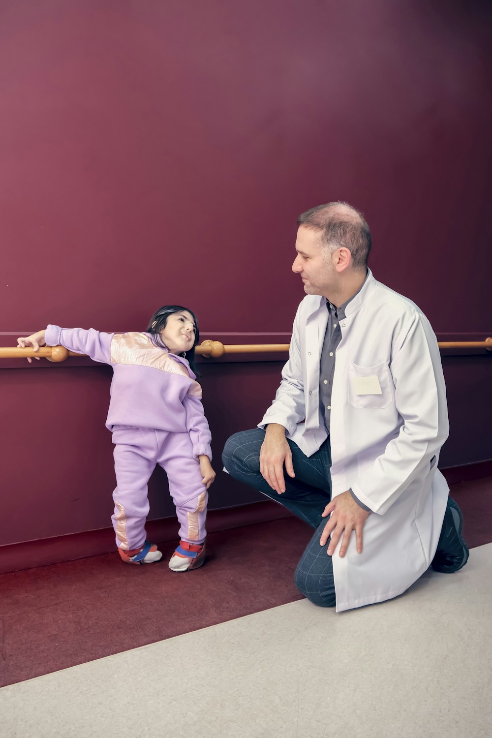 a man kneeling down next to a little girl