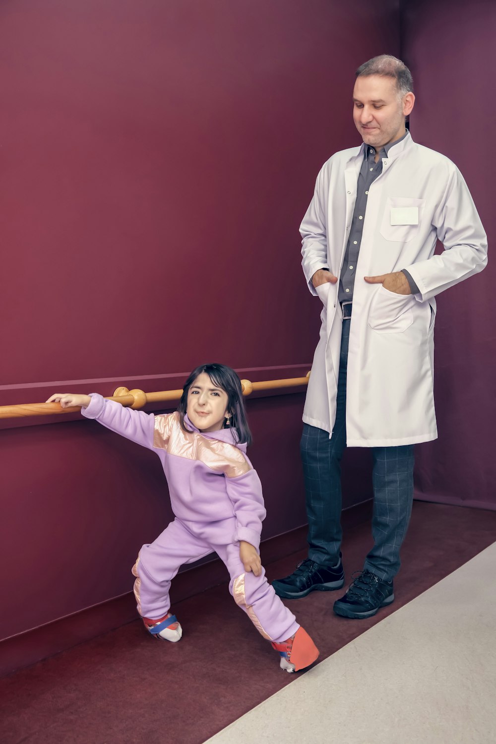 a man standing next to a little girl in a room