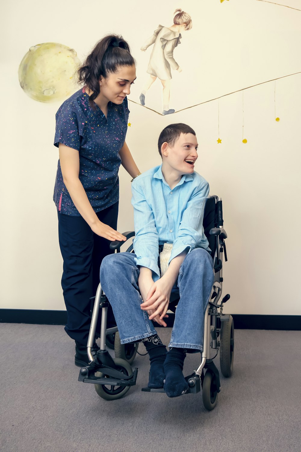 a woman standing next to a man in a wheel chair