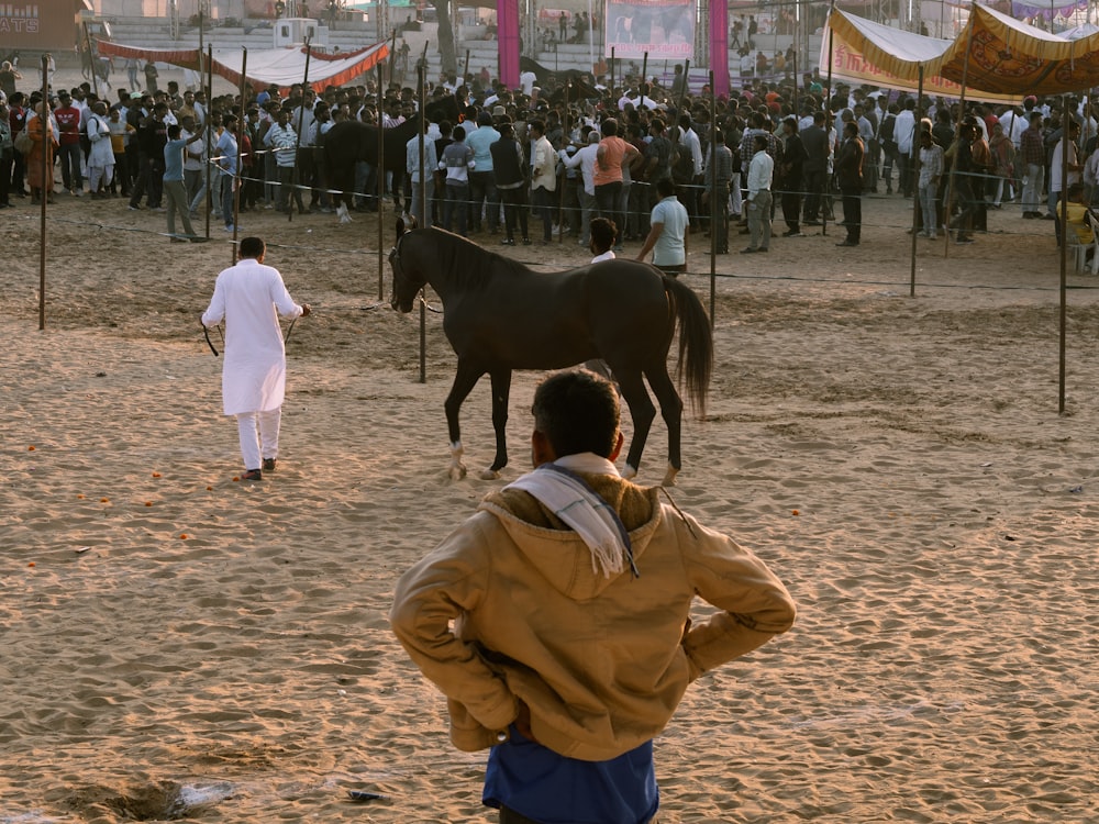 a man standing in front of a black horse