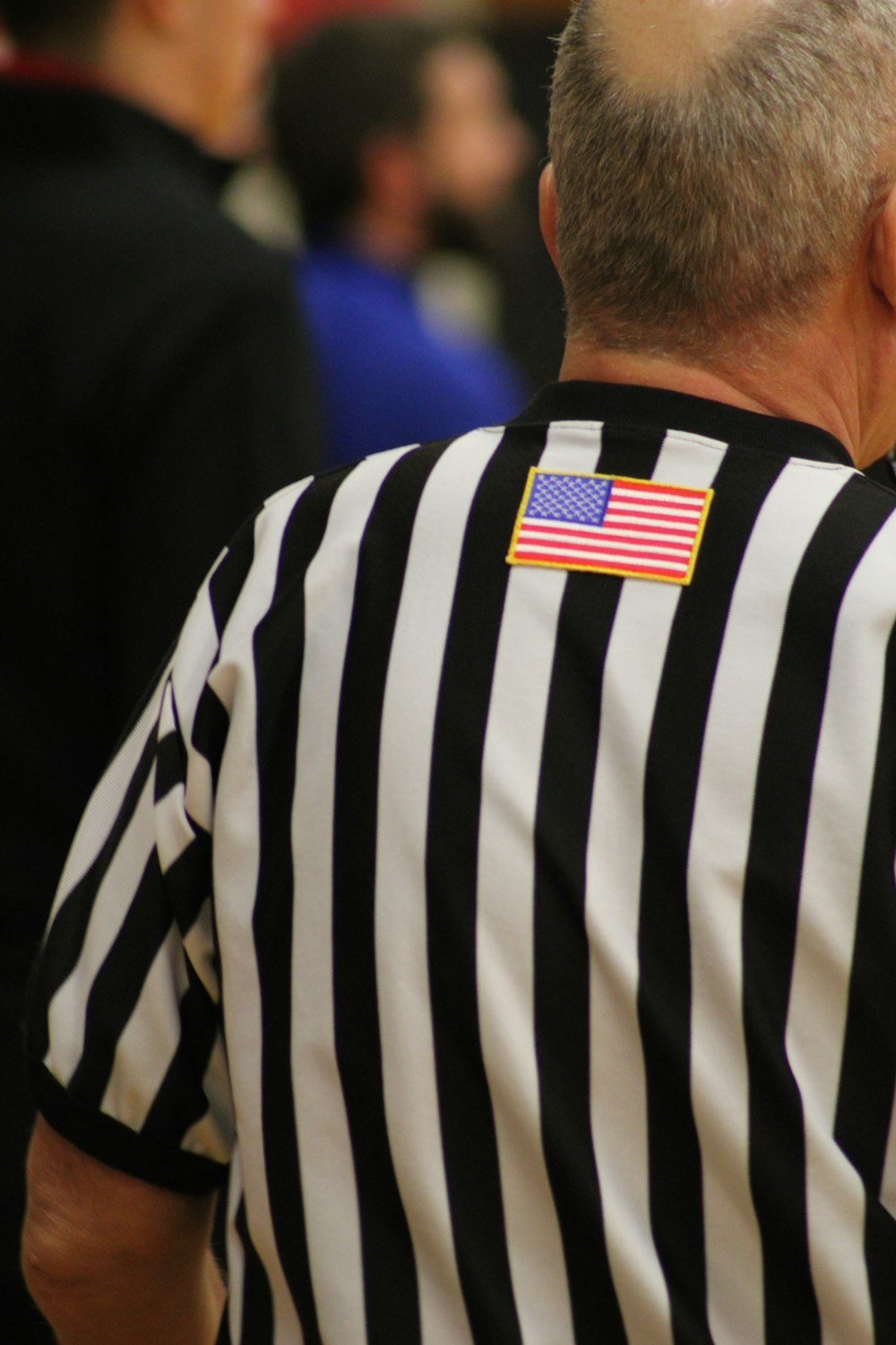 Un homme en uniforme d’arbitre avec un écusson du drapeau américain sur le dos