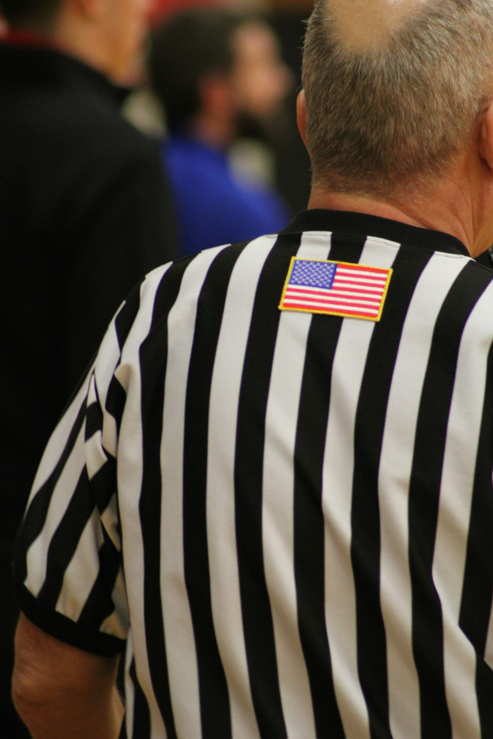 a man in a referee's uniform with an american flag patch on his back