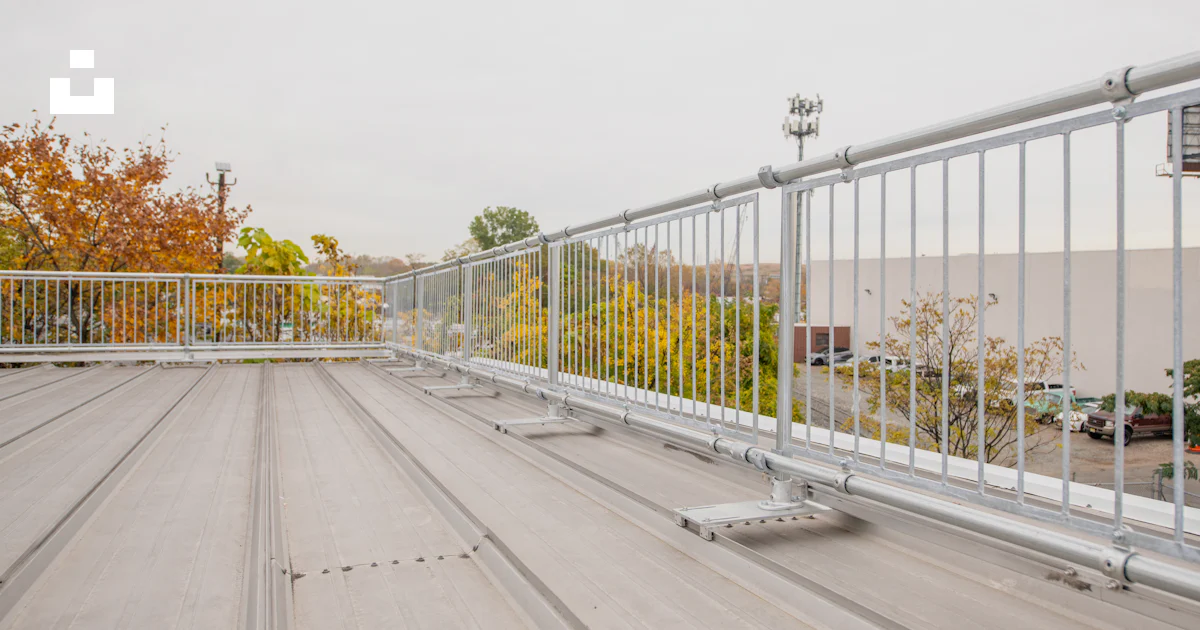 Parking Railing Work A metal railing on a roof with a parking lot in the background photo ...