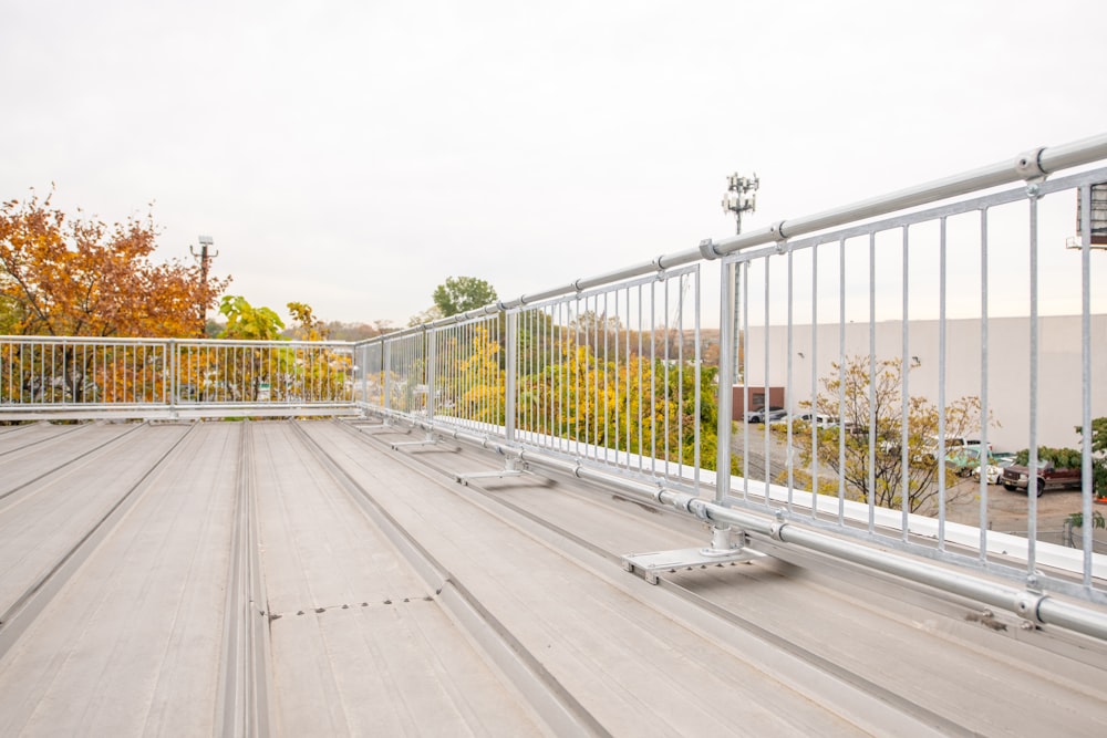 a metal railing on a roof with a parking lot in the background
