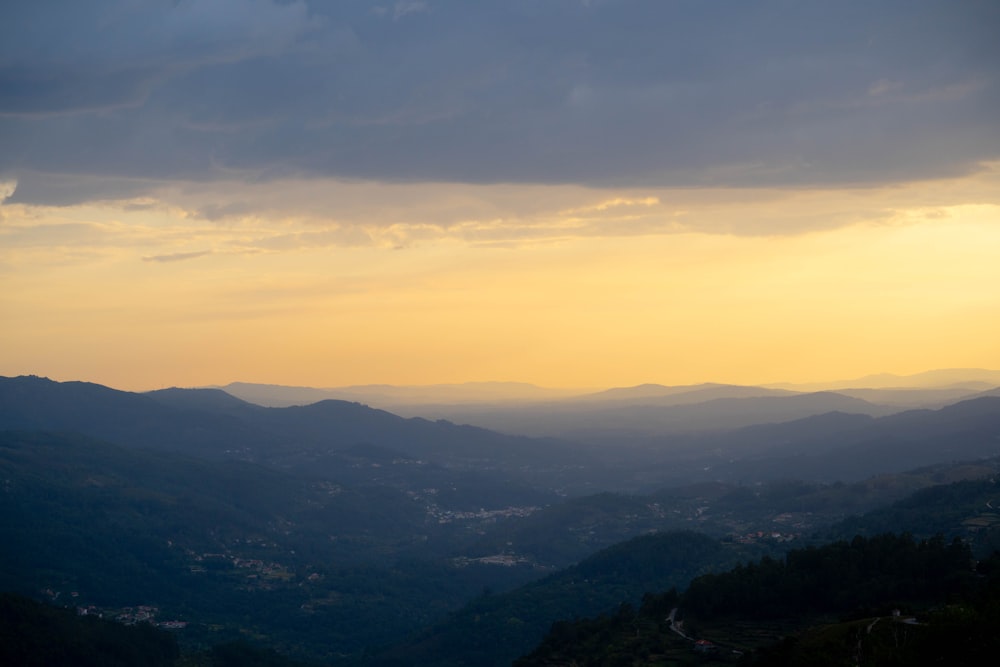 the sun is setting over the mountains in the distance