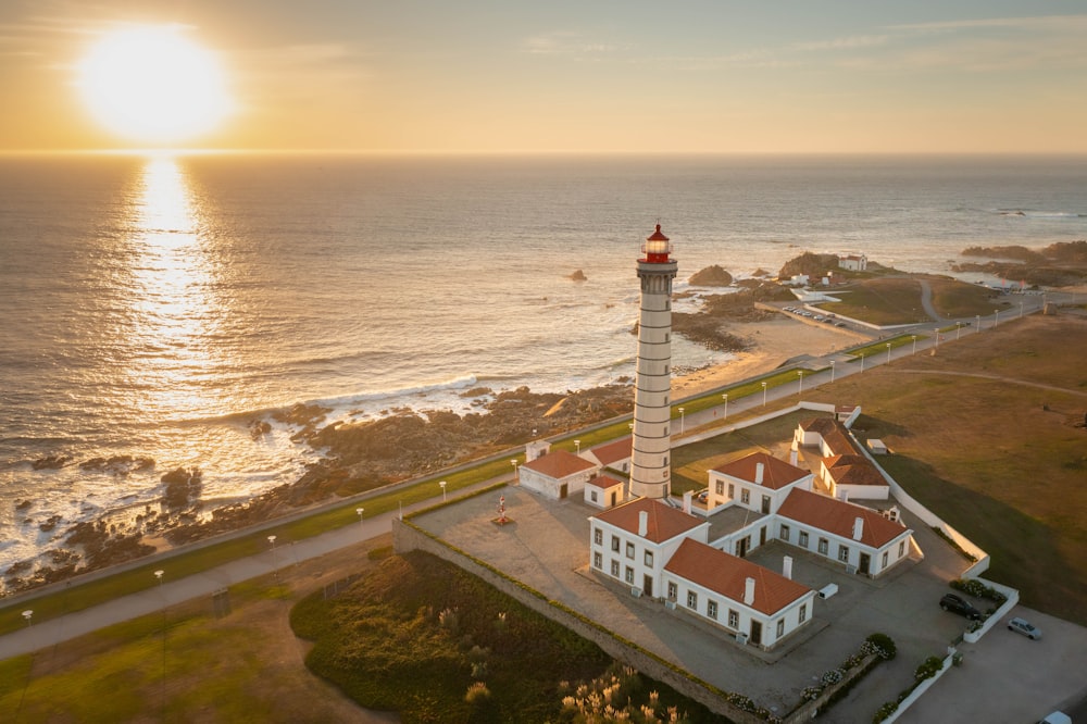an aerial view of a lighthouse with the sun in the background