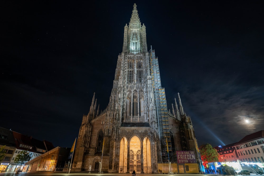 a large cathedral lit up at night in a city