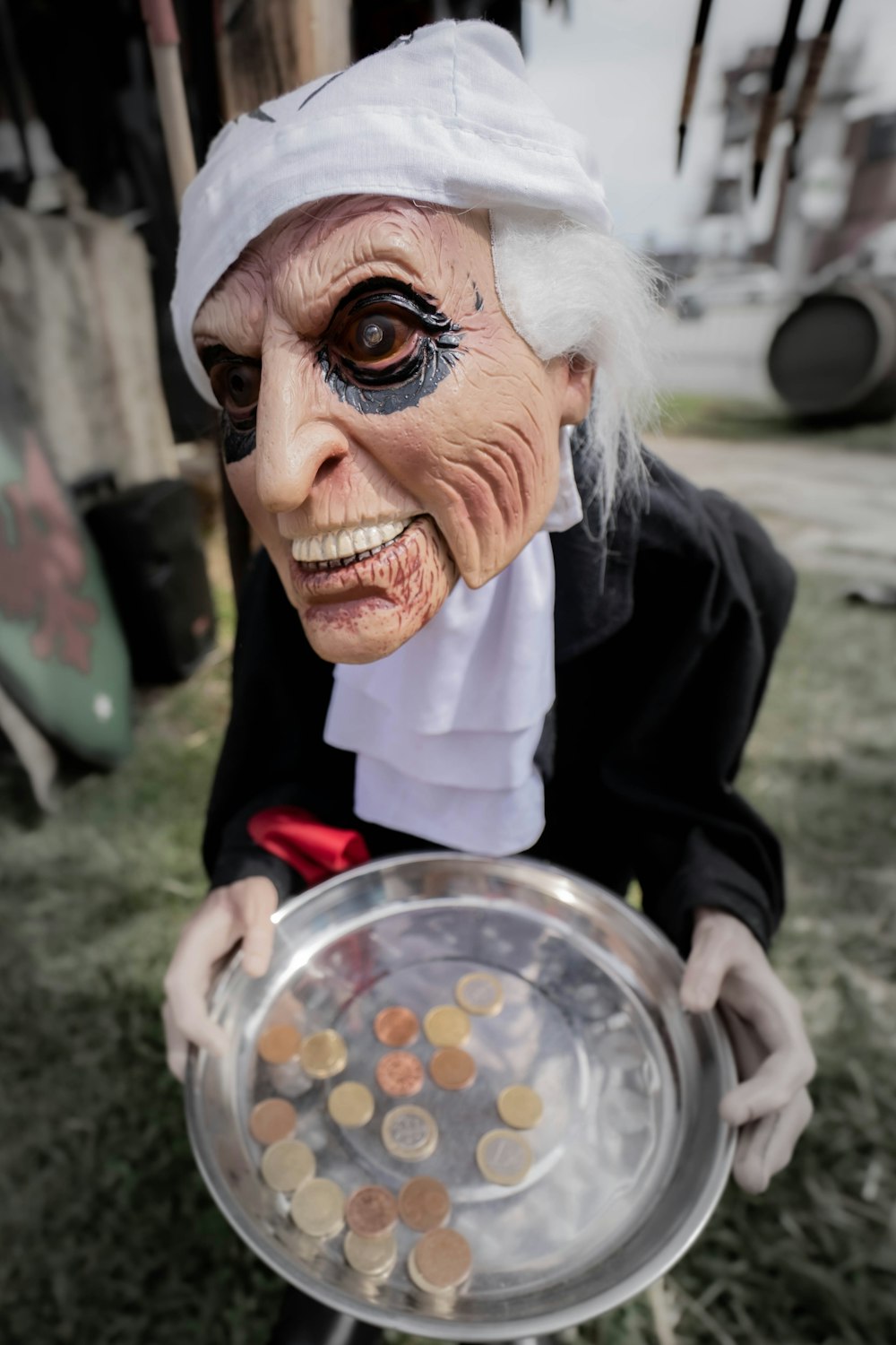 a person in a costume holding a tray of coins