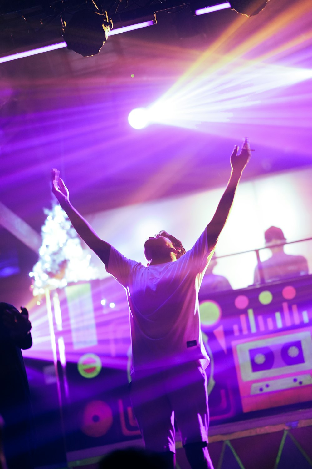 a man standing on a stage with his arms in the air