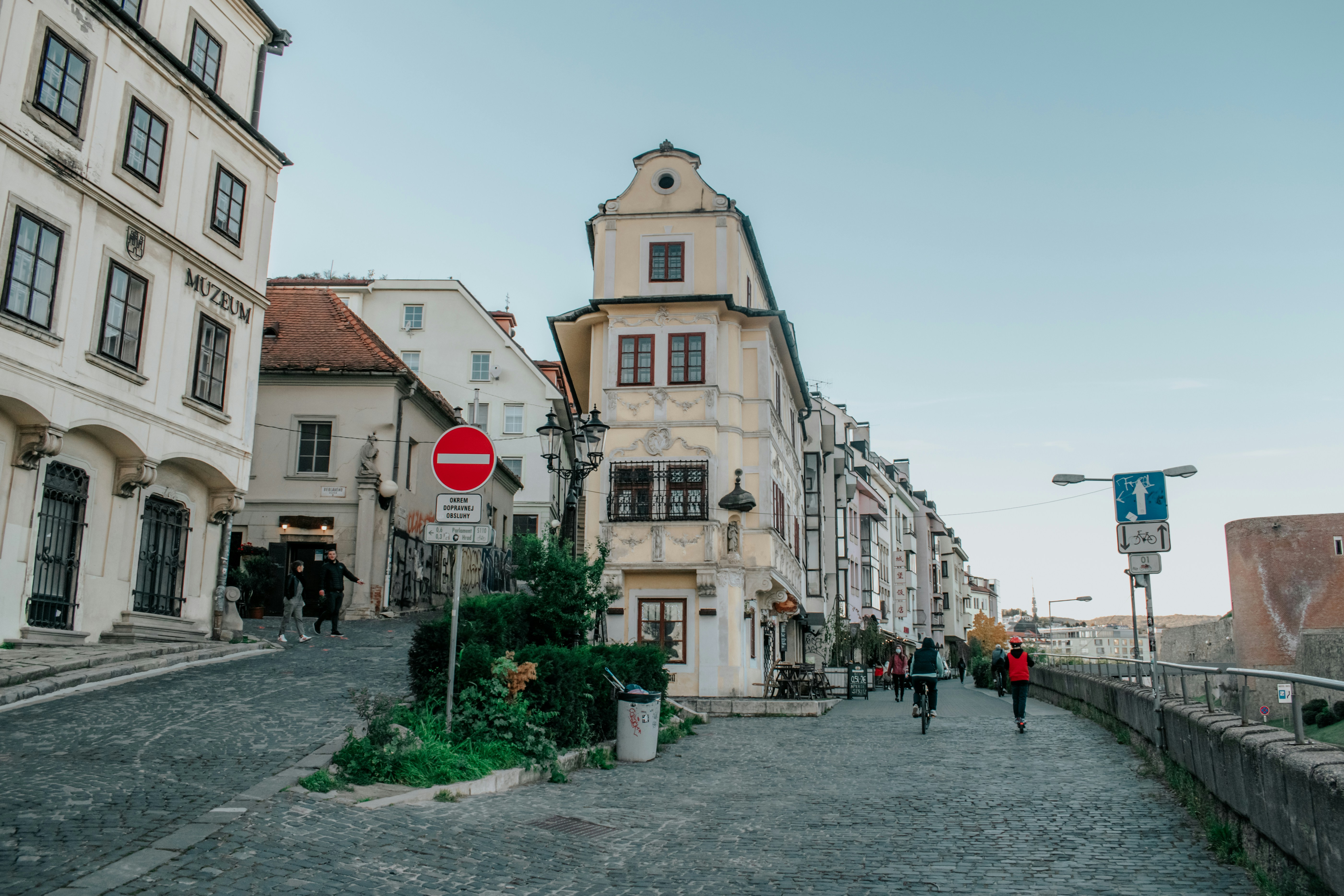 people walking down a cobblestone street in a european city, 