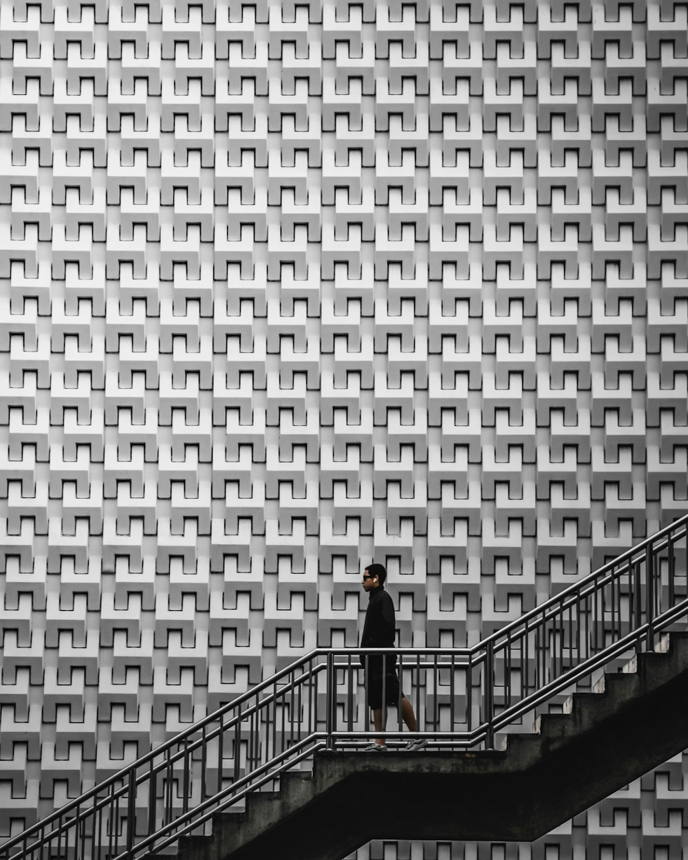 a man walking down a flight of stairs in front of a building